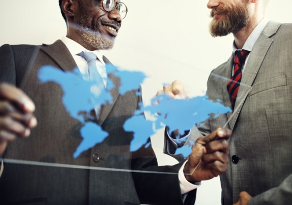 Two business professionals reviewing a global map, symbolising international tax advisory and strategic business expansion.