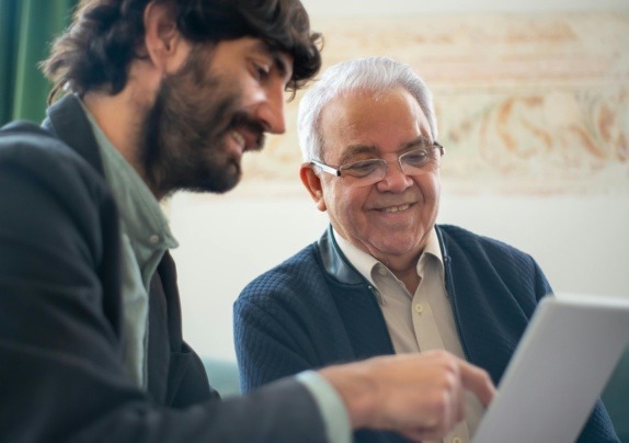 Two professionals reviewing documents on a laptop, representing trust and estate tax planning and compliance discussions.