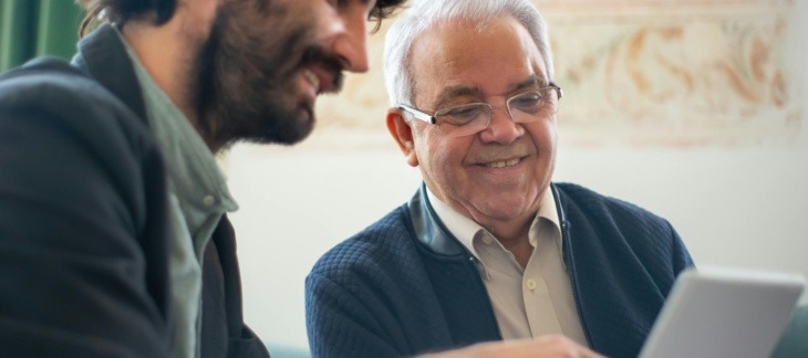 Two professionals reviewing documents on a laptop, representing trust and estate tax planning and compliance discussions.